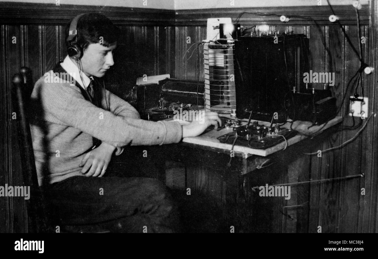 A teenage boy communicates with a telegraph, ca. 1915. Stock Photo