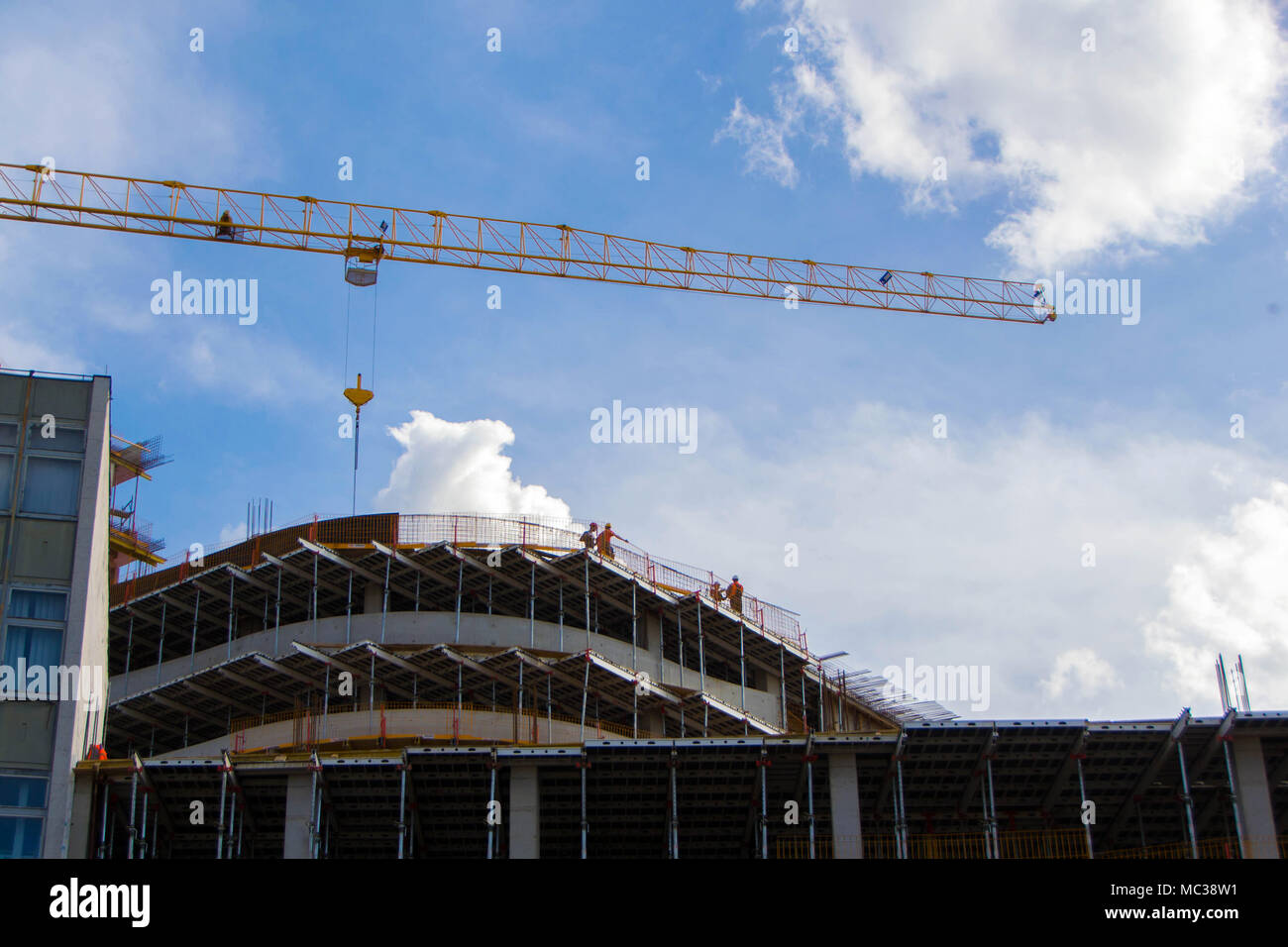Crane and construction workers. Workers on multi-story building. Stock Photo