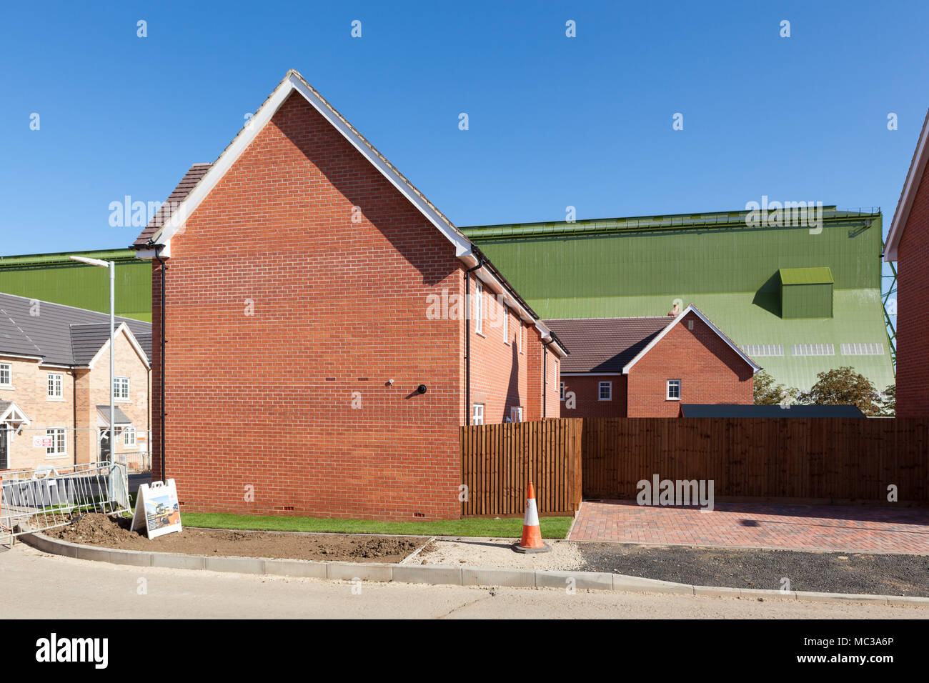 New build estate with Cardington airship hanger behind, Bedford, UK Stock Photo