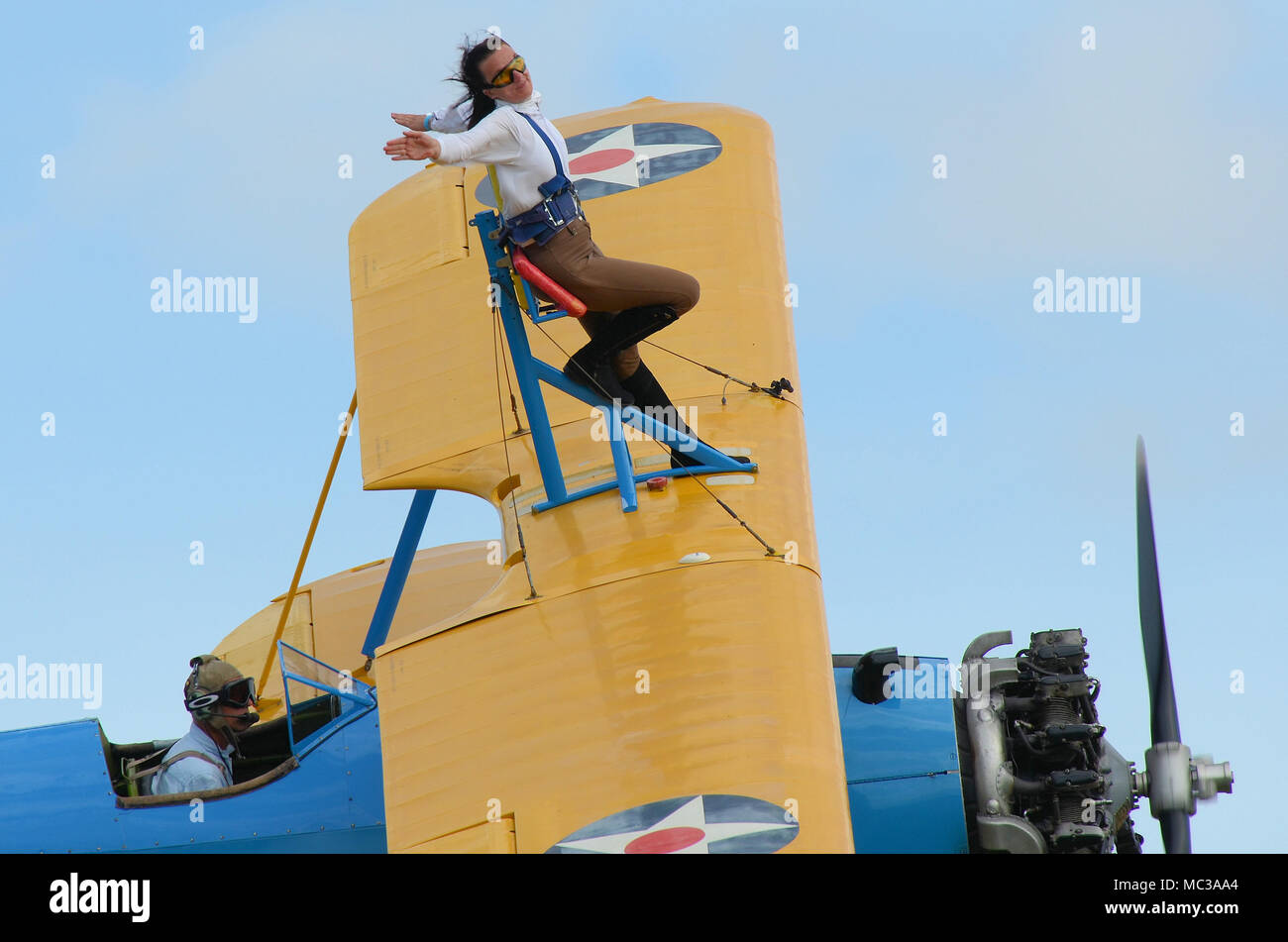 Sarah Niles wingwalking on a Boeing Stearman at Damyns Hall Aerodrome, Essex, UK, with Aerobatic Tactics. Girl on the wing, wing walking Stock Photo