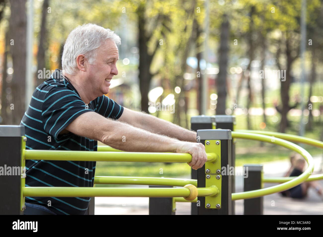 Old man resting after doing physical exercises in the fitness park Stock Photo