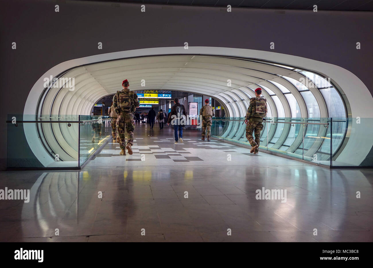 Pedestrian tunnel with four soldiers walking through, Toulouse Blagnac airport, France Stock Photo