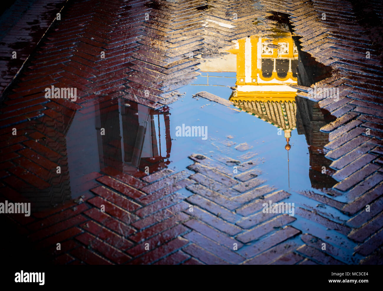 The reflection of Rosina's Balcony (El Balcón De Rosina) in a puddle in Santa Cruz after rain in the Spanish city of Seville, Andalusia, Spain Stock Photo