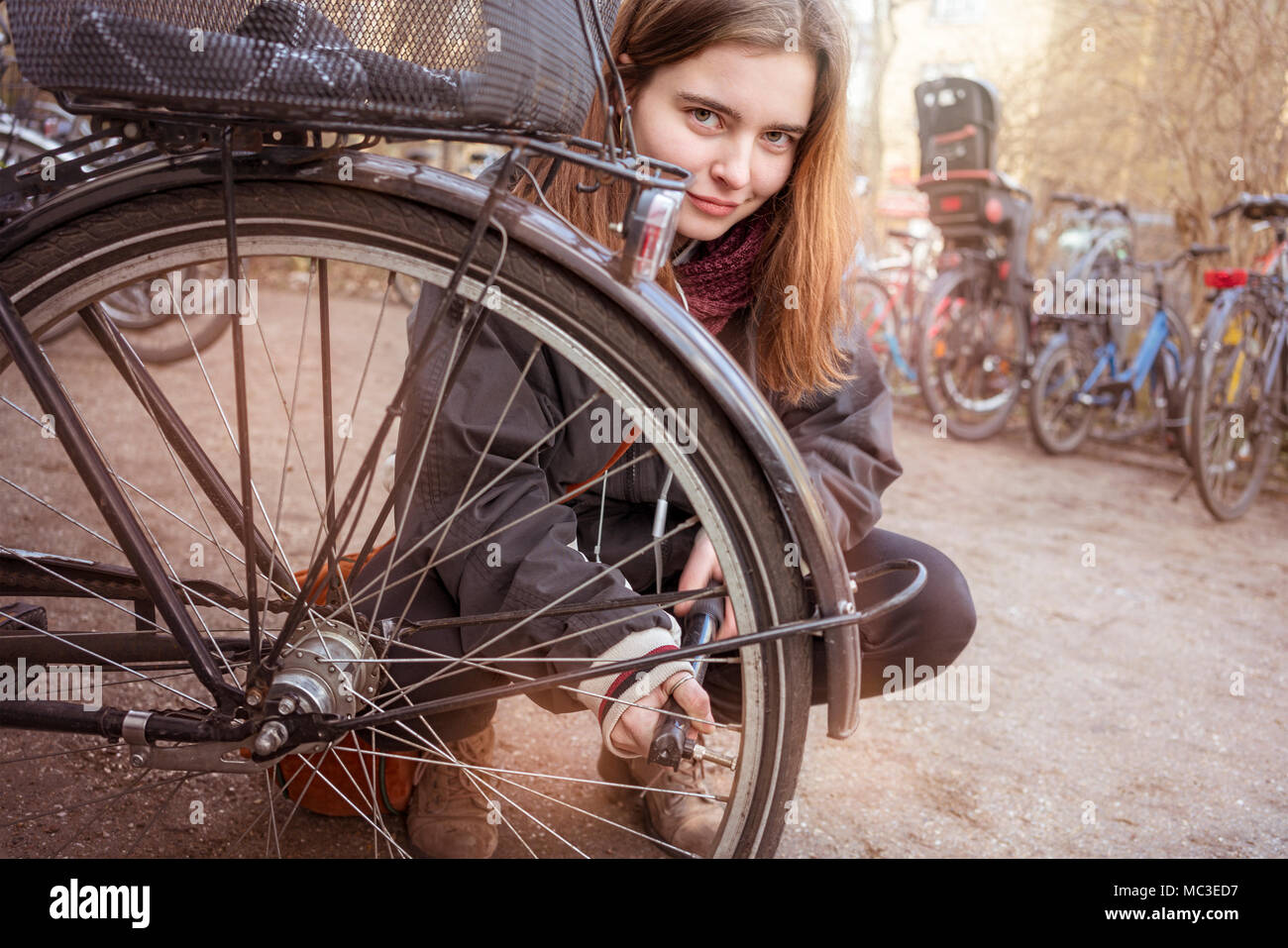 Young woman pumps up the tires of her bike Stock Photo Alamy