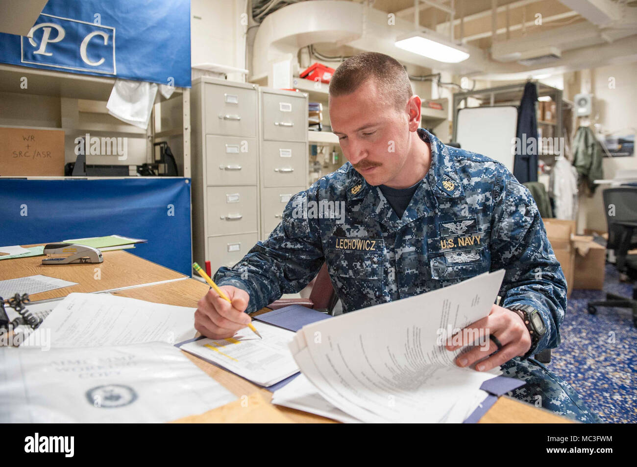 NAVAL BASE SAN DIEGO (April 2, 2018) Chief Aviation Electronics Technician Jason Lechowicz, a native of New Britain, Conn., assigned to the amphibious assault ship USS America (LHA 6), reviews the monthly maintenance plan in the aircraft intermediate maintenance department production control room. America is moored at her homeport of Naval Base San Diego and is beginning a planned maintenance availability period in preparation for her next tour of duty. Stock Photo