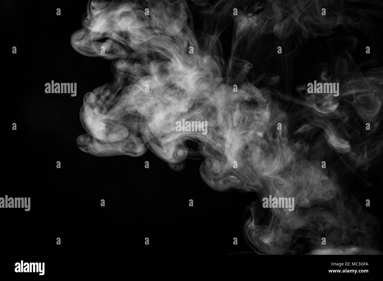 Dense white smoke on a black isolated background. Background of smoke vape Stock Photo