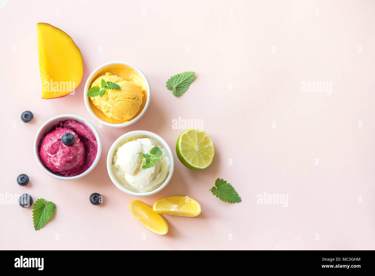 Three various fruit and berries ice creams on pink background, copy