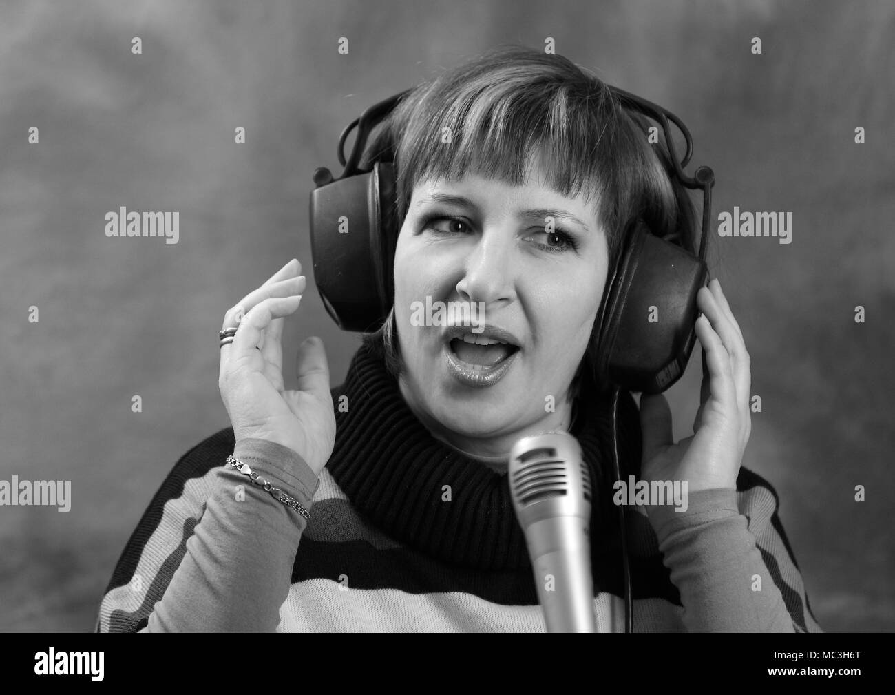 Portrait of a woman in headphones singing music. Stock Photo