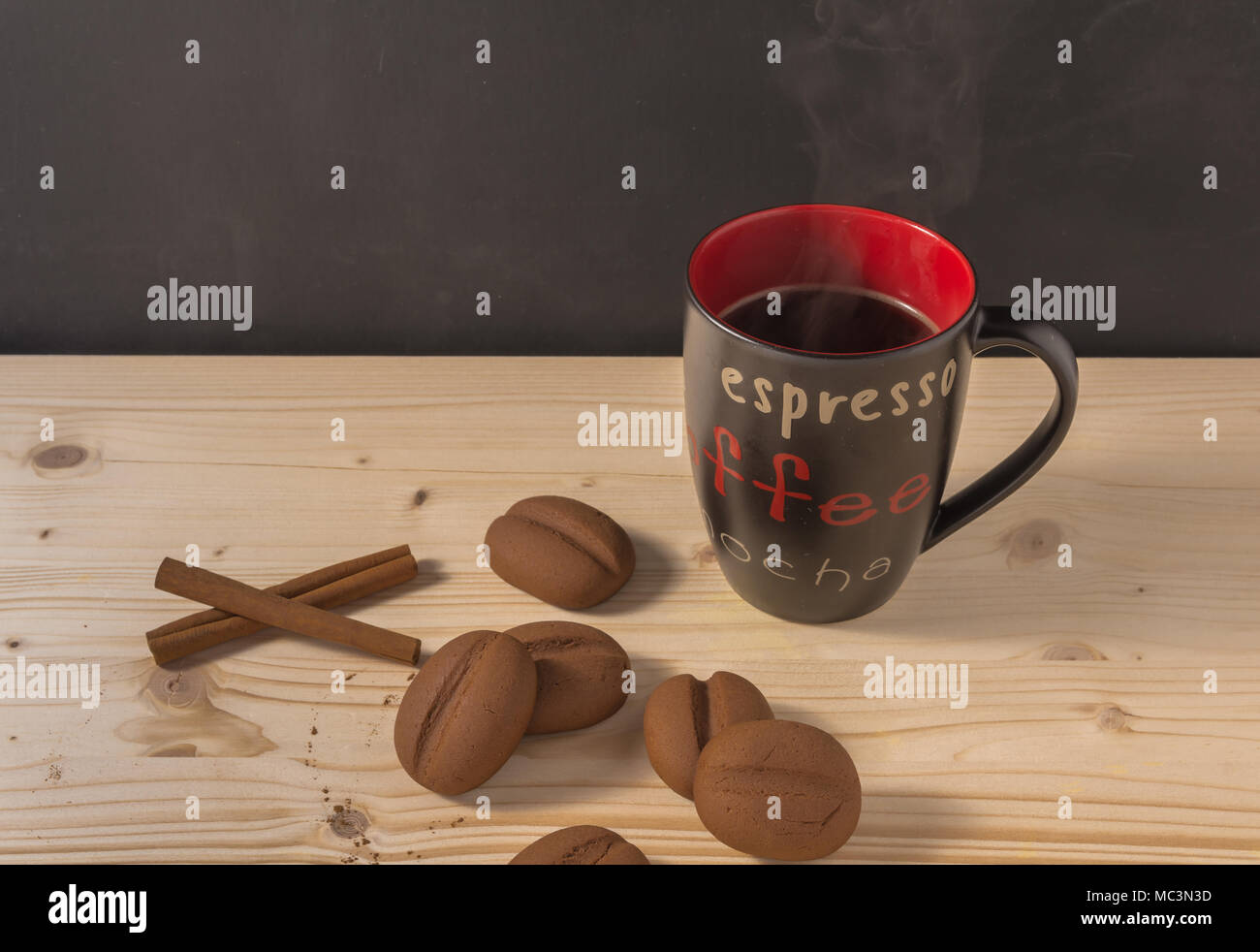 Coffee in a black mug with coffee beans shape cookies Stock Photo