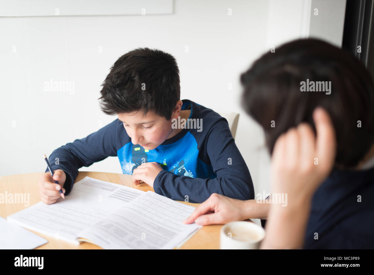 Private tutoring at home-10-11 years boy  having a maths lesson at home Stock Photo