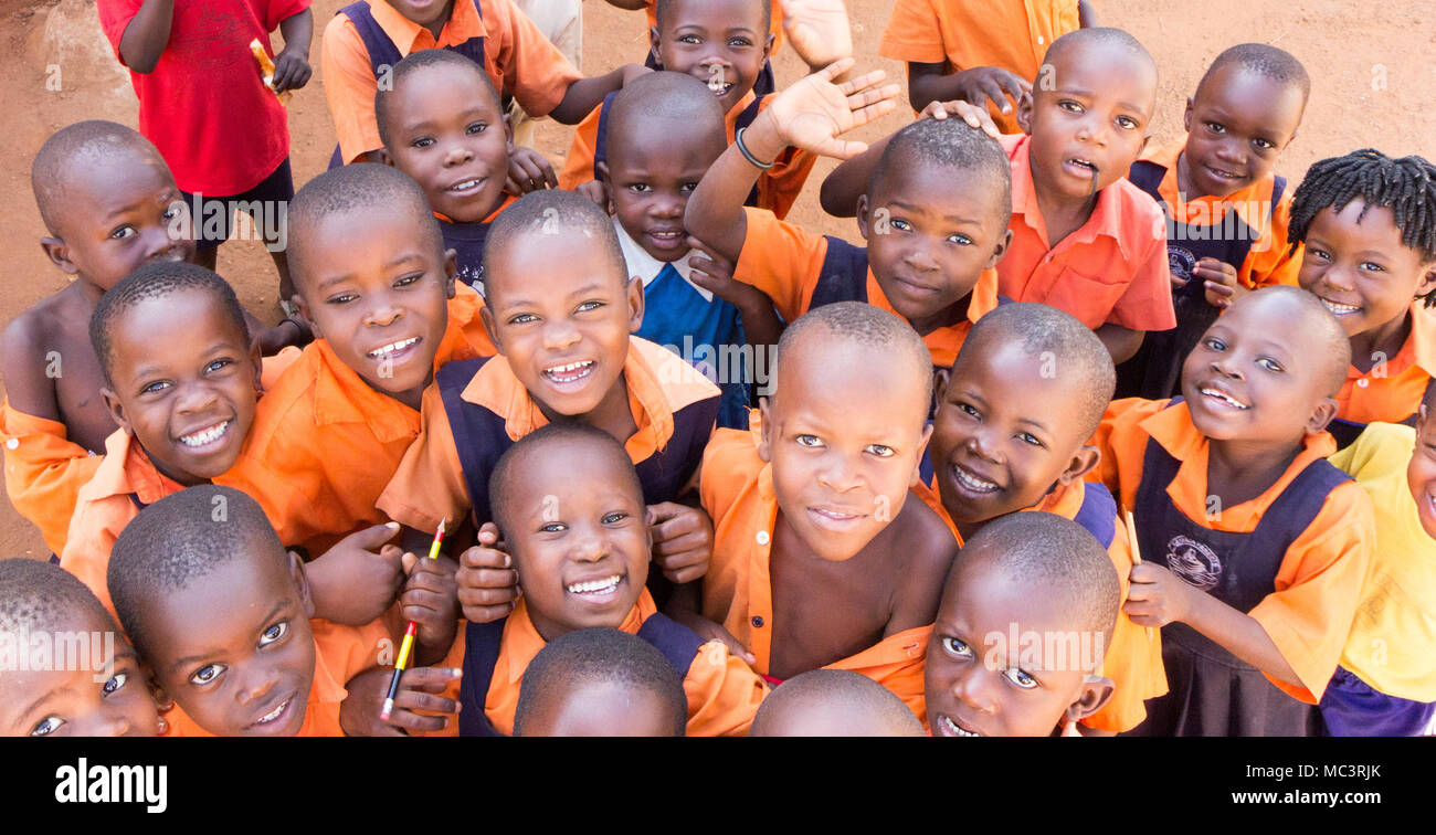 Uganda. June 13 2017. A group of happy primary-school children smiling, laughing and waving at a primary school. Stock Photo