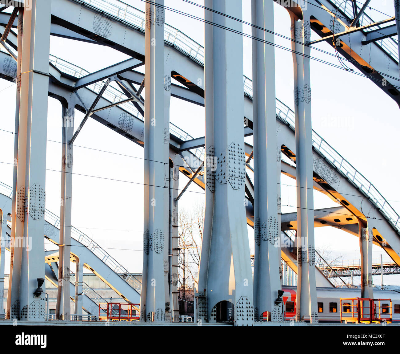 landscape with railway with trains, lot of steel rafters at sunset ...
