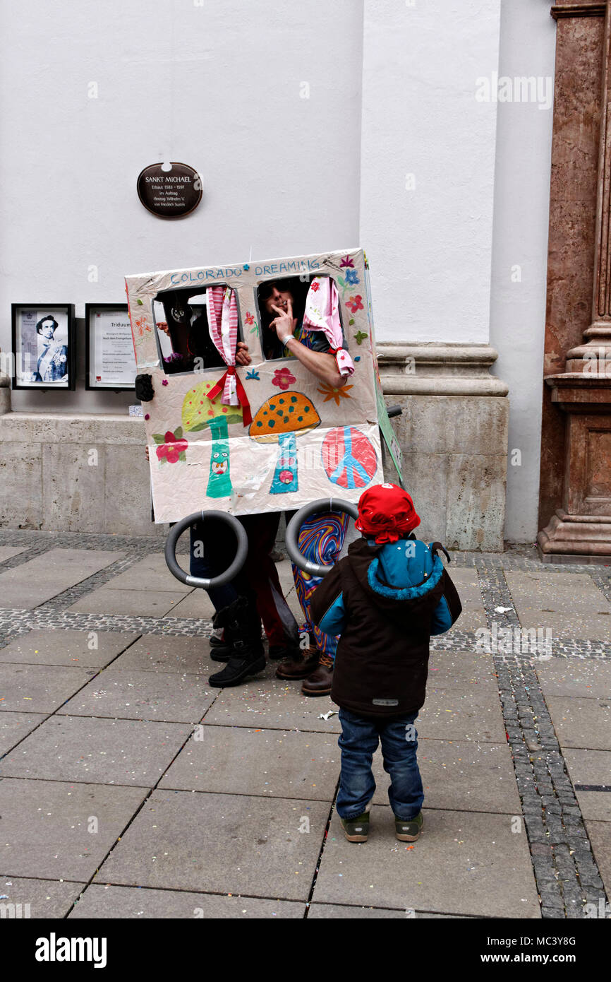 Child watching men in a hippie box, Fasching street party, Munich, Upper Bavaria, Germany, Europe Stock Photo