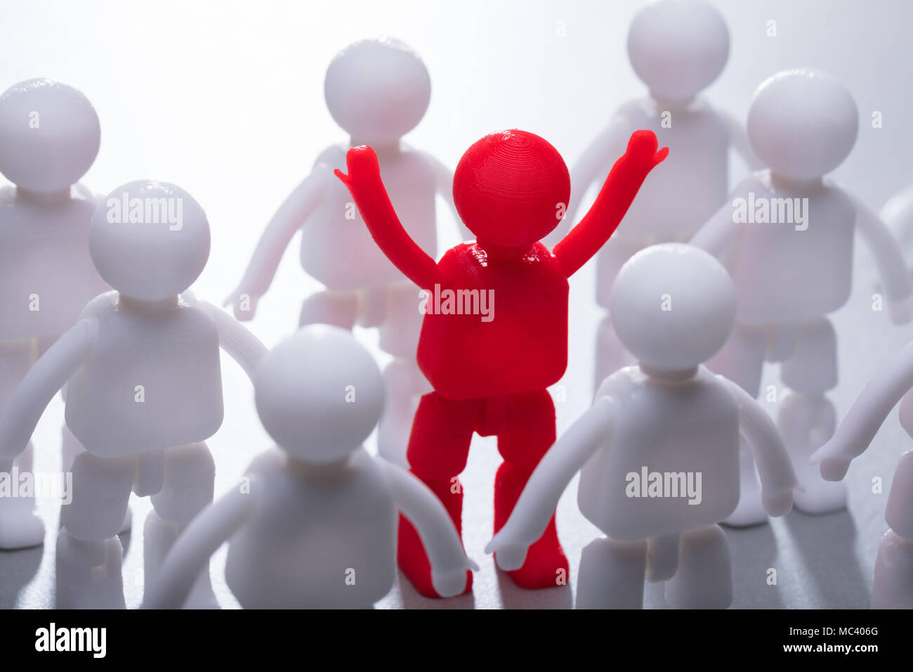 Red Human Figure Surrounded By Team Representing Unity Stock Photo