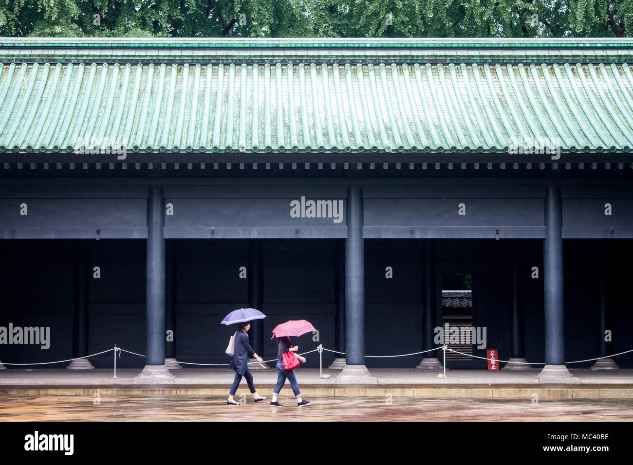Tokyo, Japan. Two Japanese women walking with an umbrella in the rain inside Yushima Seido, a Confucian temple in the Yushima neighbourhood of Bunkyo Stock Photo