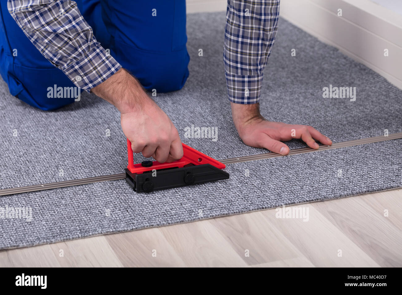 Close-up Of A Male Carpet's Hand Fitter Installing Carpet With Tool Stock Photo
