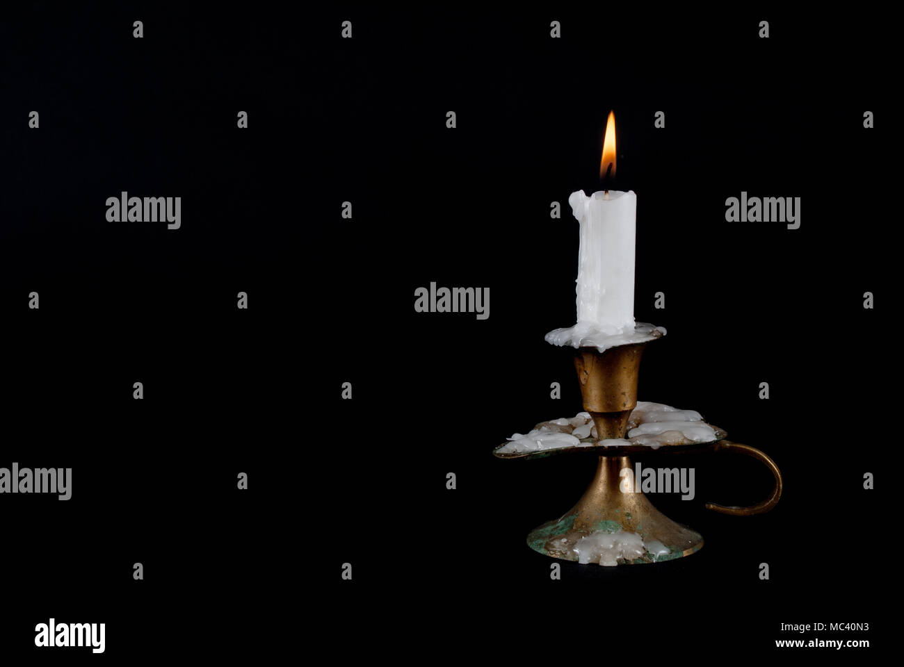 Candle burning and old candlestick isolated on black background and ...