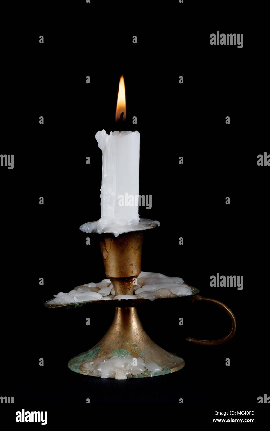 Paraffin Candle burning and old candlestick isolated on black
