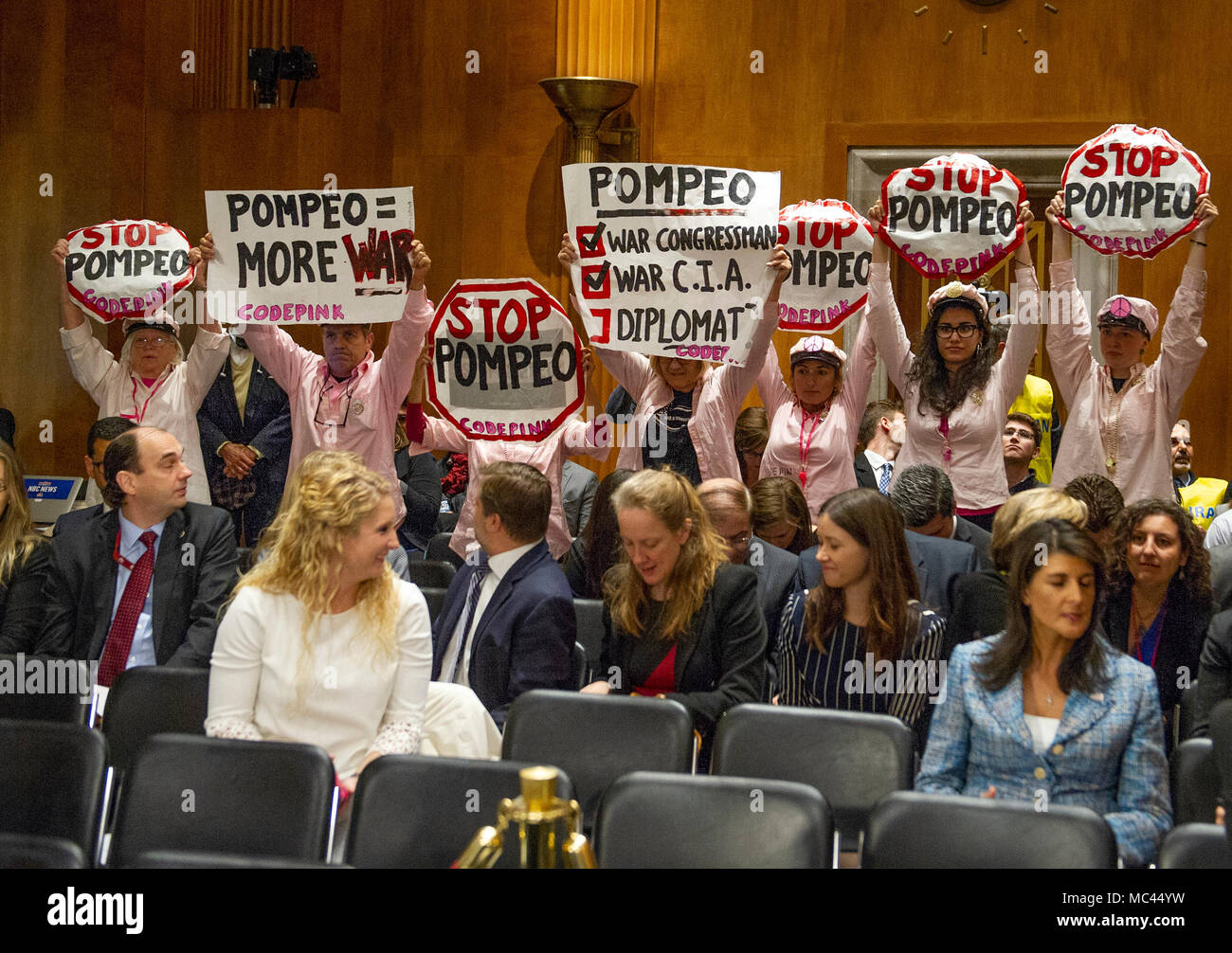 Protestors hold up signs prior to the arrival of CIA Director Mike Pompeo, who will testify on his nomination to be United States Secretary of State before the US Senate Committee on Foreign Relations on Capitol Hill in Washington, DC on Thursday, April 12, 2018. Credit: Ron Sachs/CNP /MediaPunch Stock Photo