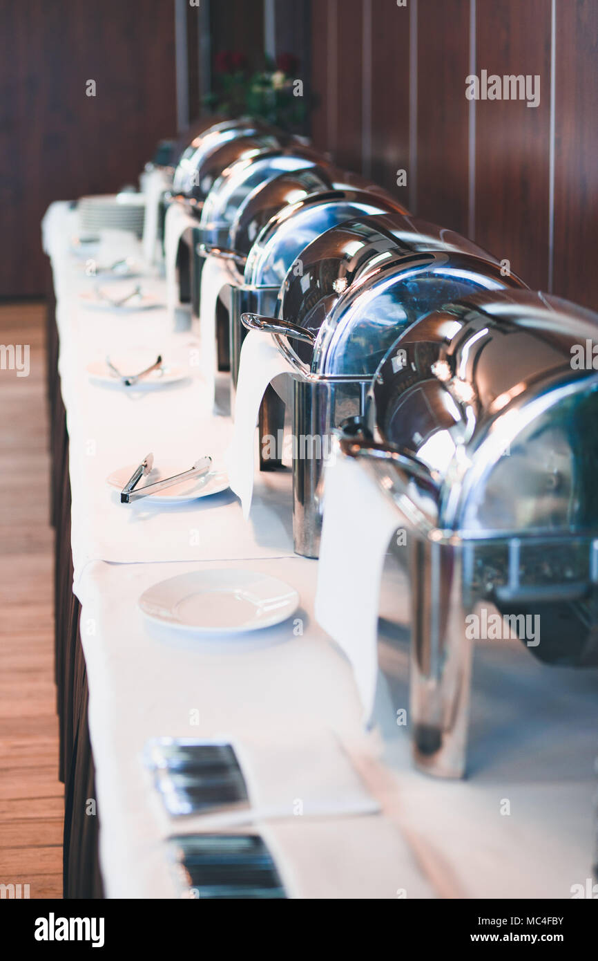 Buffet lunch with chafing dishes food warmers roll tops dinnerware. Restaurant in a hotel