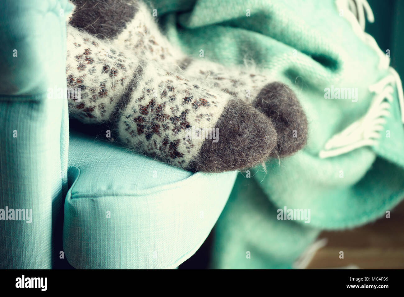 Feet in woolen socks. Cozy autumn evening. Winter and Christmas holidays concept. Copy space Stock Photo