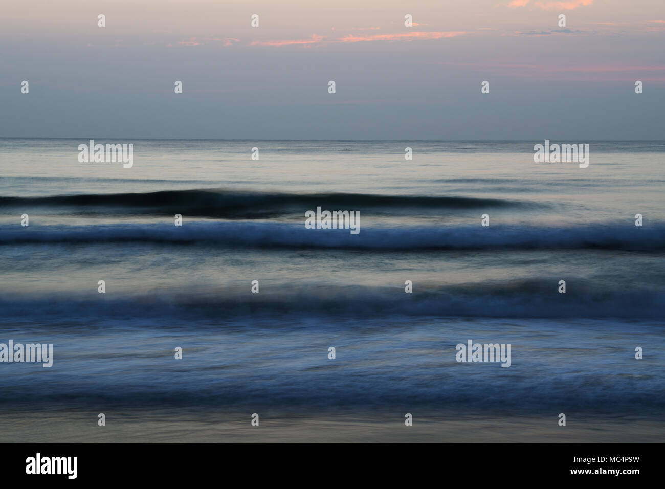 Emotionally powerful ocean sunrise with blurred waves Stock Photo