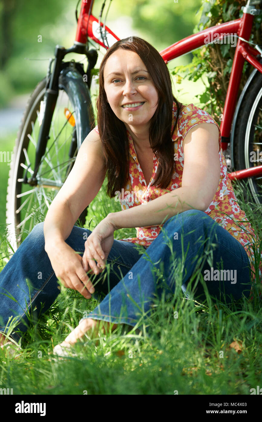 Portrait Of Mature Woman On Cycle Ride In Countryside Stock Photo