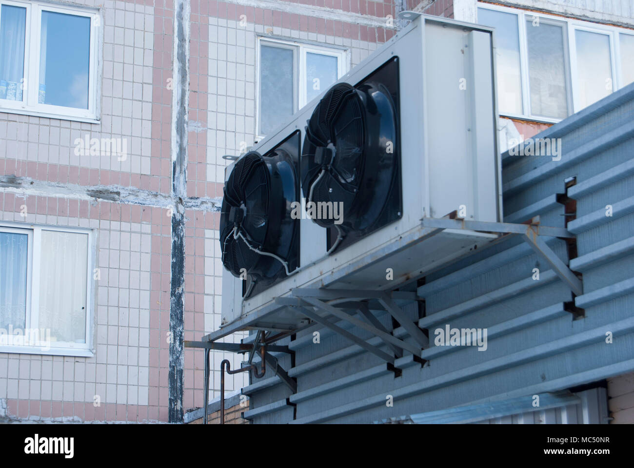 Two large black industrial fans from the air conditioner on the wall of the store Stock Photo