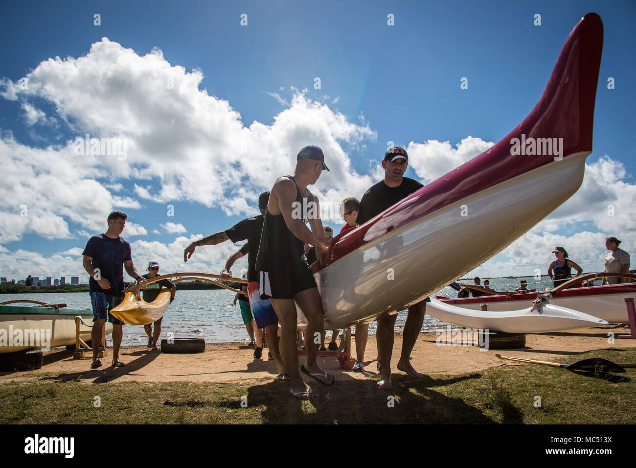 Outrigger canoeing boat team pulls their canoe out of the water after