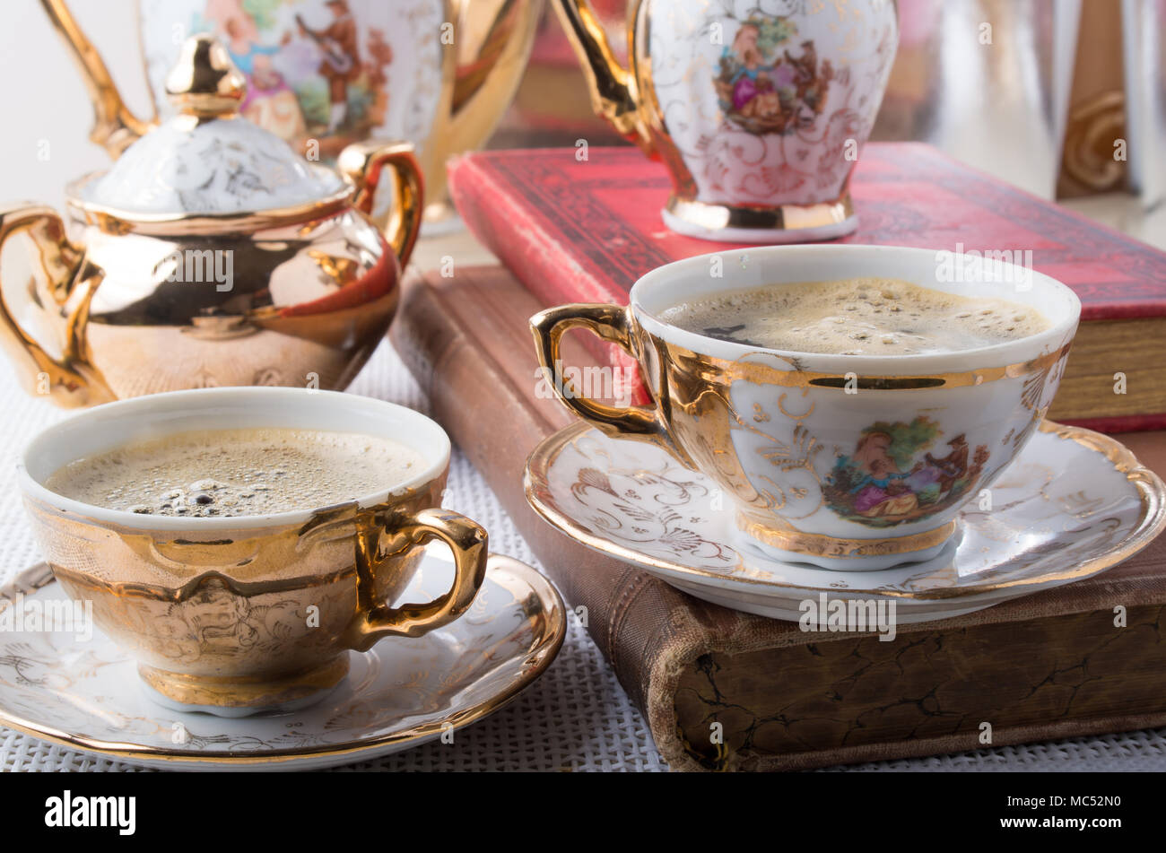 Antique porcelain coffee cups with hot coffee and crockery from the
