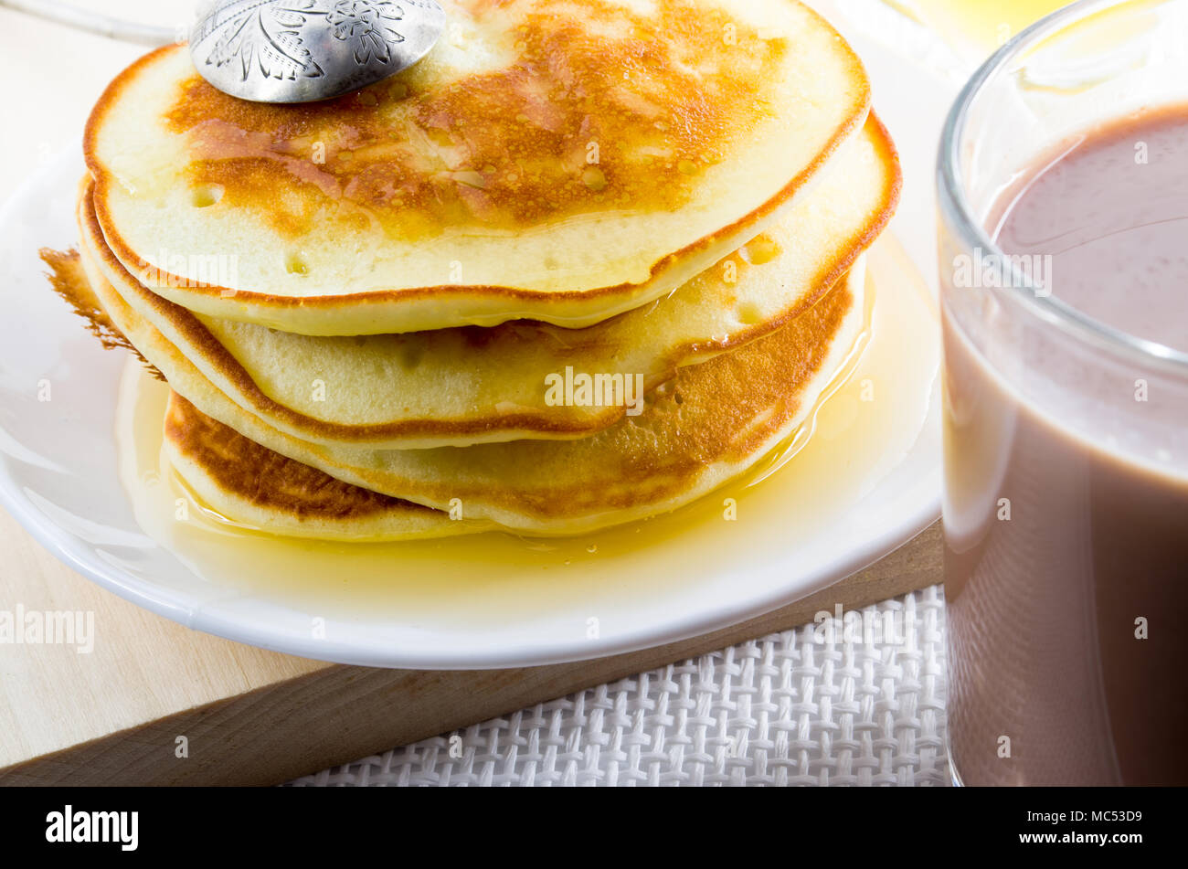 A mug of hot cocoa and pancakes with honey close-up with shallow depth of focus Stock Photo