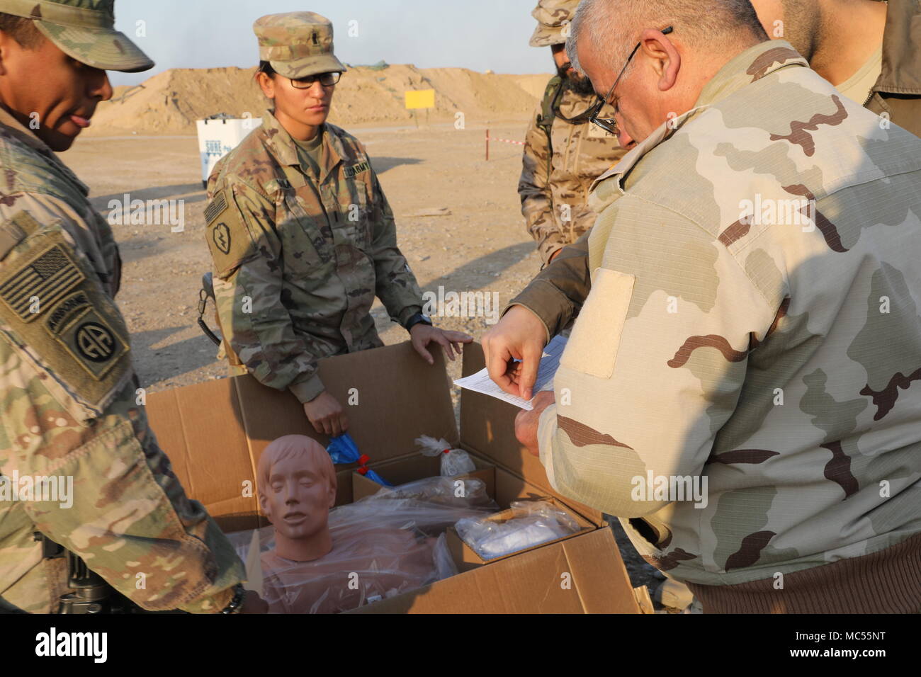U.S. Army Sgt. Chadwick Dile, left, and 1st Lt. Grisel Davila, center, both assigned to the 536th Support Maintenance Company, 275th Combat Sustainment Support Battalion, display a mannequin to an Iraqi army leader during a medical equipment transfer at the Besmaya Range Complex, Iraq, Jan. 28, 2018.  The U.S. provides training and equipment to vetted Iraqi security forces through the National Defense Authorization Act FY 2015; Iraq Train and Equip Fund. Training and equipment is in support of the Combined Joint Task Force – Operation Inherent Resolve mission to defeat and deny ISIS safe haven Stock Photo