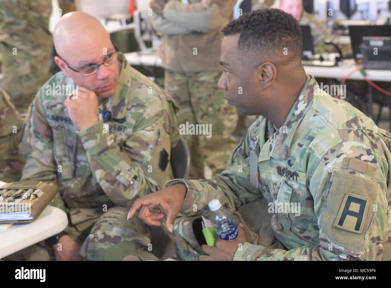 Capt. Zantionyo Goodwin (right), a maintenance observer coach/trainer with First Army’s 174th Infantry Brigade, talks with Lt. Col. Ron Humphrey, chief of Logistics for the Pennsylvania Army National Guard's 28th Infantry Division, during the 28th ID’s culminating training exercise at Fort Hood, Texas, Jan. 30, 2018. The 28th ID is preparing to deploy to the Middle East, where the unit will support Operation Spartan Shield. 'First Army has been very helpful, both in training and in the real world, assisting us with things like (requests for information). Overall, I think they’ve done well with Stock Photo