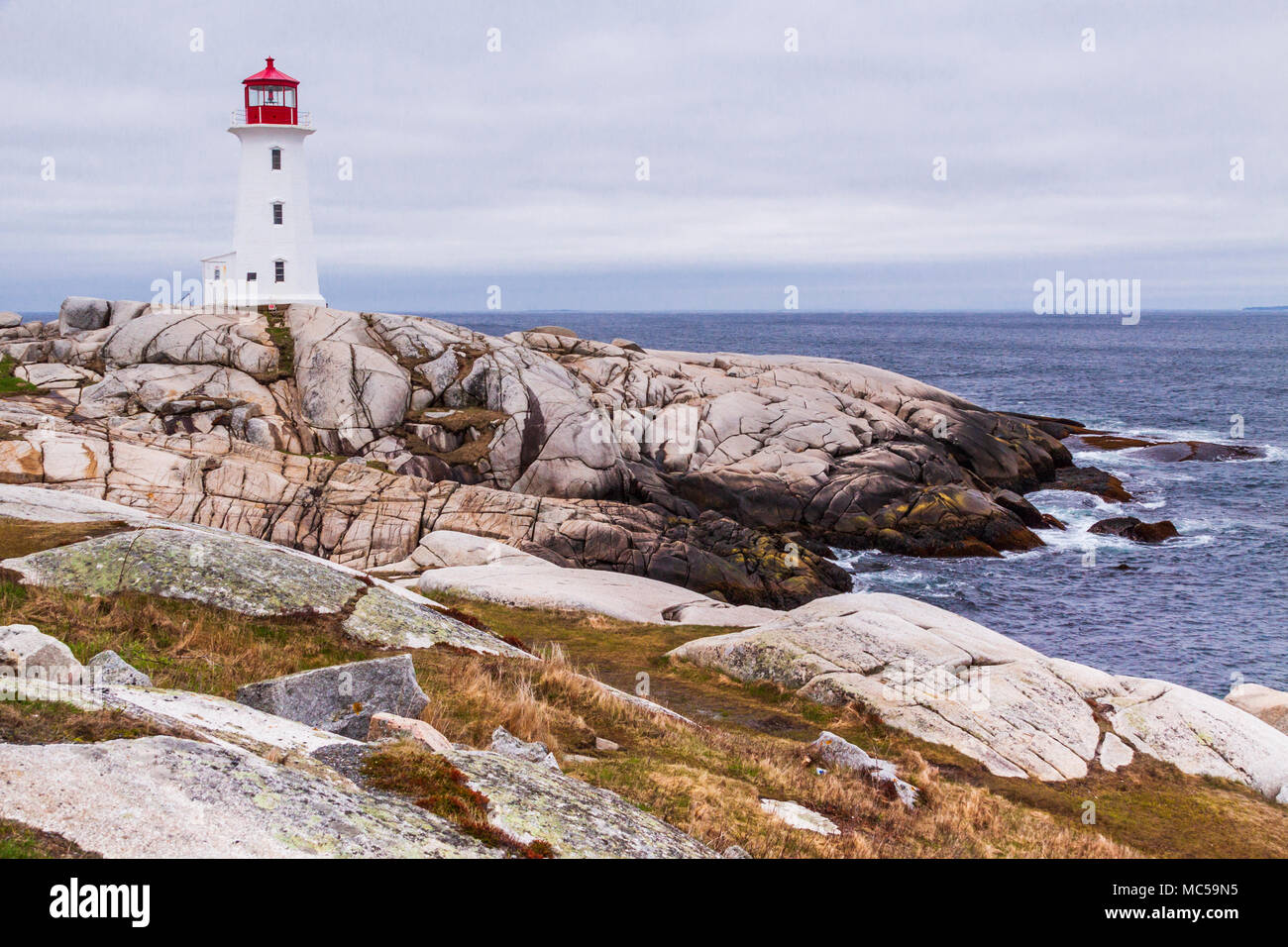 Peggy's Point Lighthouse on a stormy day in May at Peggy's Cove near Halifax, Nova Scotia, Canada, was first erected in 1868. Stock Photo