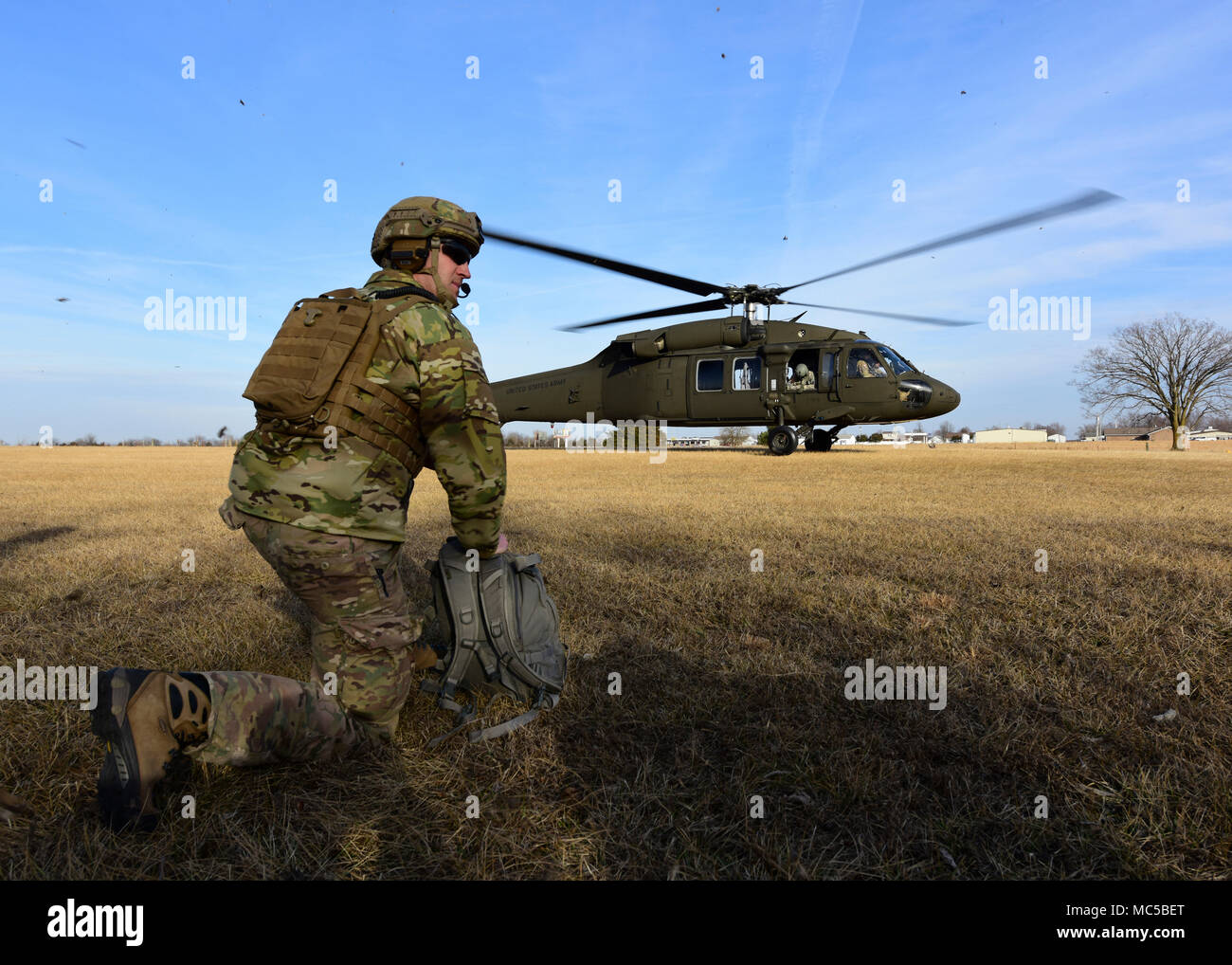 A Joint Terminal Attack Controller assigned to the 7th Air Support Operations Squadron, located in Fort Bliss, Texas, waits for a UH-0 Black Hawk land during a joint training at Warsaw, Mo., Jan. 31, 2018. JTACs are personnel who are authorized to call airstrikes and help coordinate close-air-support missions. (U.S. Air Force by Staff Sgt. Danielle Quilla) Stock Photo
