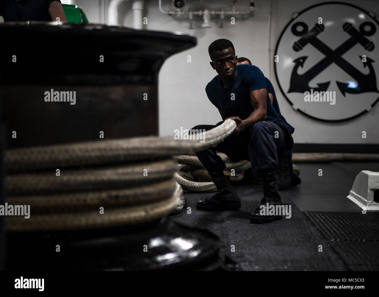 180402-N-TV230-1541 SINGAPORE (April 2, 2018) Seaman Robert Minson handles a mooring line in the fo’c’sle of the aircraft carrier USS Theodore Roosevelt (CVN 71) during a regularly scheduled port call to Singapore. Theodore Roosevelt is deployed in the U.S. 7th Fleet area of operations in support of maritime security operations and theater security cooperation efforts. (U.S. Navy photo by Mass Communication Specialist Seaman Bill M. Sanders/Released) Stock Photo