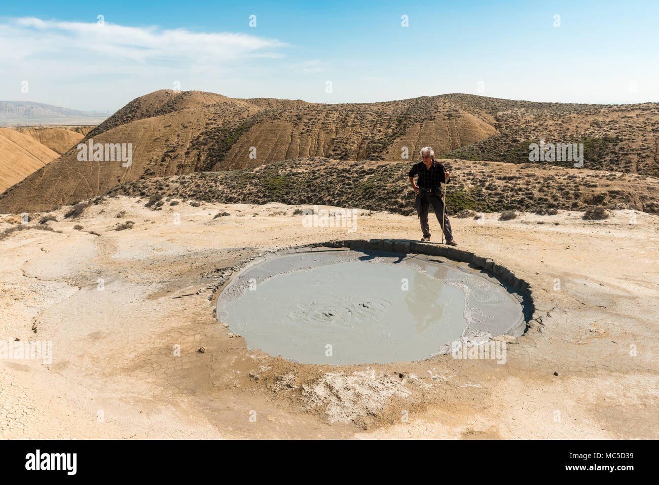 A traveler near the crater of a mud volcano Stock Photo