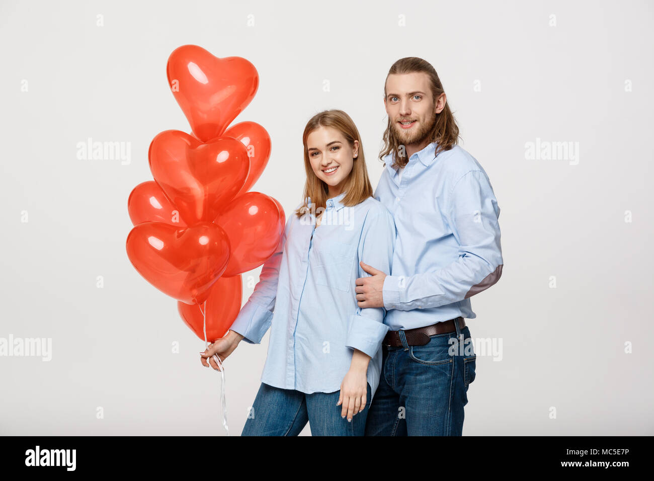 Hugging Balloons Portrait of young fashionable caucasian couple with balloons heart ...