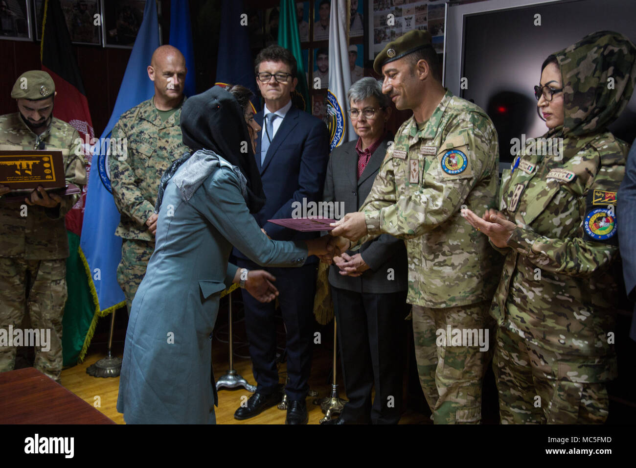 Afghan Lt. Col. M. Khetab Khangari, First General Command of Police Special Units commander, presents a certificate to a Female Foundation Course graduate as Australian Ambassador to Afghanistan Nicola Gordon-Smith and Norwegian Deputy Ambassador to Afghanistan John Almster look on at the Special Police Training Center, Camp Wak, Kabul, Afghanistan, Apr. 5, 2018. (U.S. Army photo by Austin T. Boucher) Stock Photo