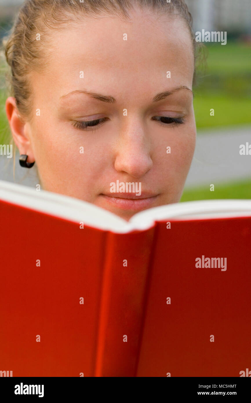outdoor portrait of pretty woman with red book Stock Photo - Alamy