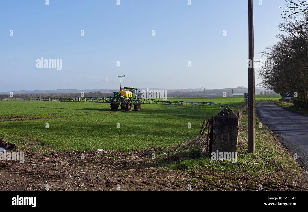 A John Deere Crop Sprayer starts work in a field beside Station Road in