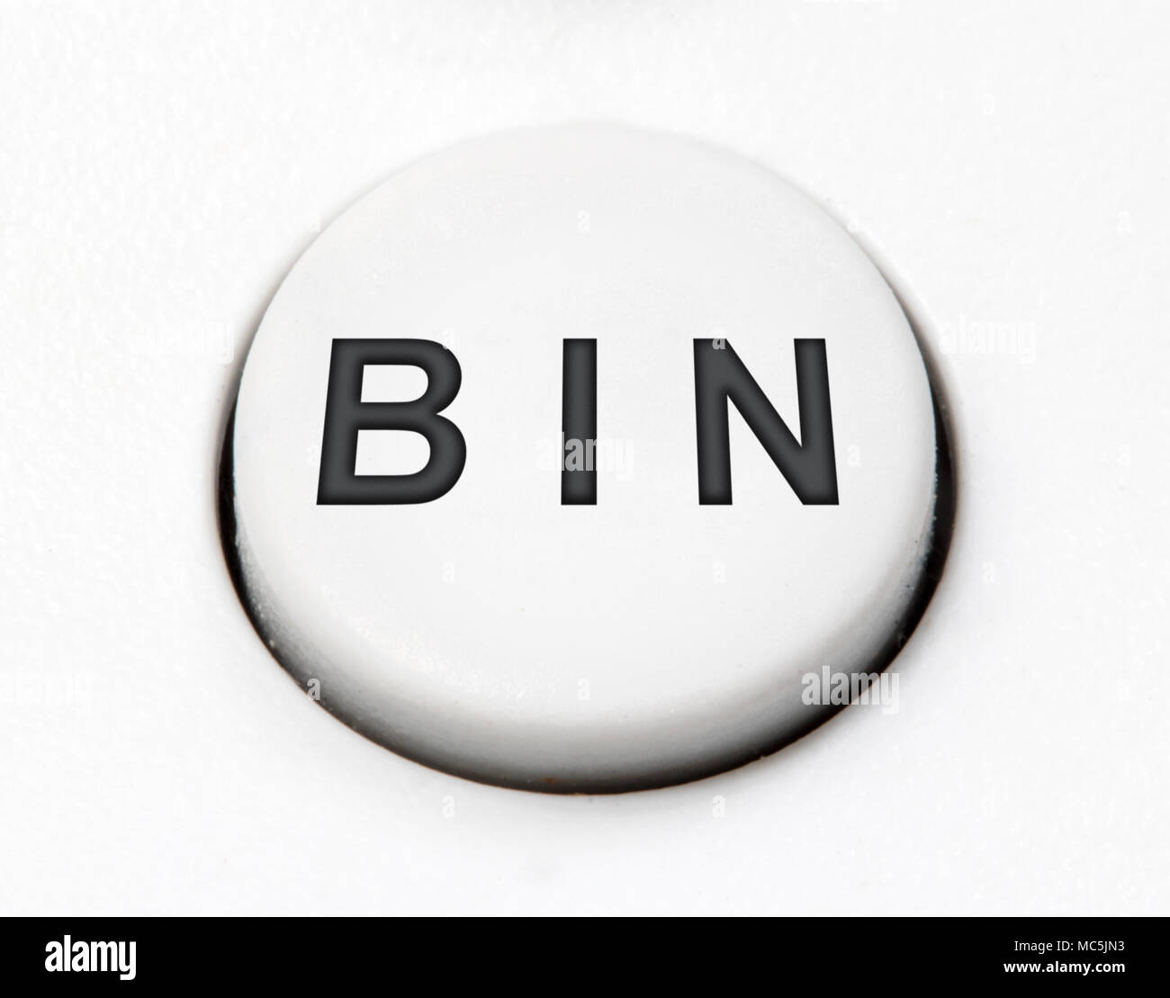 A white round button switch - bin, close up. Control mechanical key for delete on control device. Stock Photo