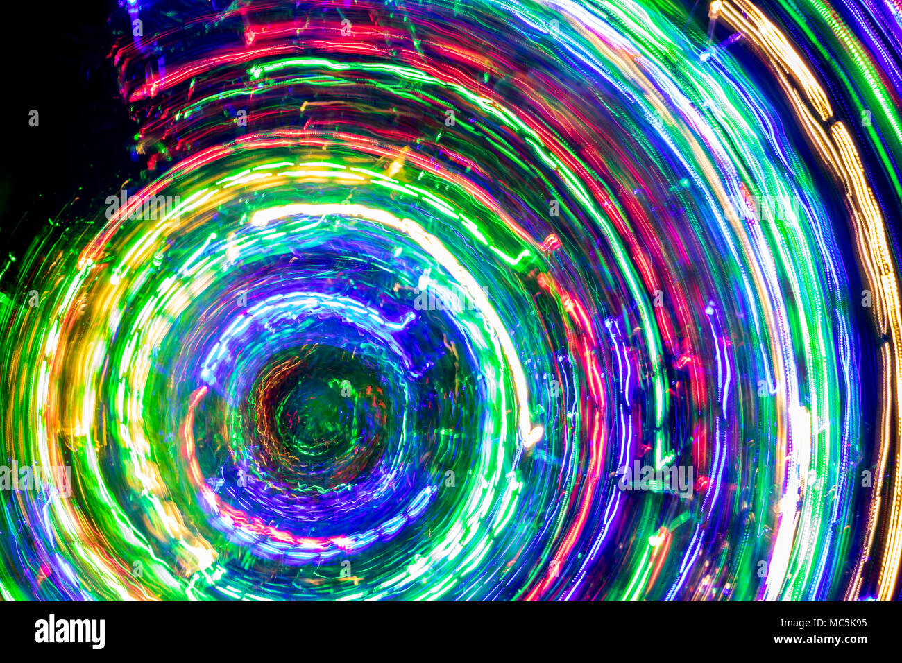 The round of blurred lines of color lights on dark background. Colorful lights blurred by motion. Stock Photo