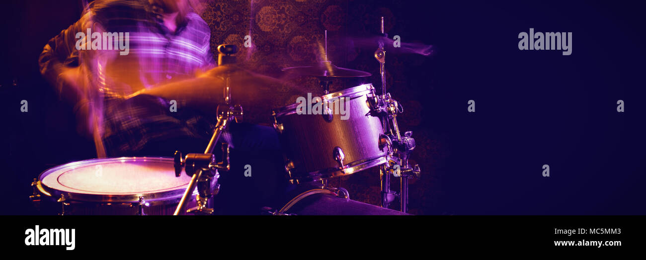 Blurred motion of male drummer in nightclub Stock Photo
