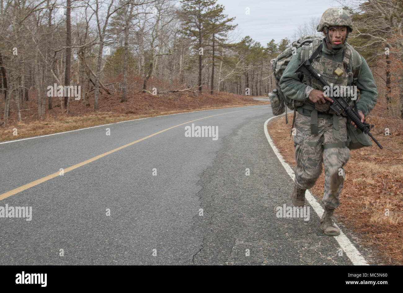 JOINT BASE CAPE COD, Mass. – Senior Airman David Montanez of the 104th Security Forces Squadron hustles in full battle rattle April 7, 2018 to the next station of the Massachusetts National Guard’s Best Warrior Competition here.  The annual event challenges some of the most qualified soldiers and airmen in the state to draw on their skills and grit to earn the title and a chance to move onto the national competition.  (Massachusetts Army National Guard photo by Spc. Samuel D. Keenan) Stock Photo