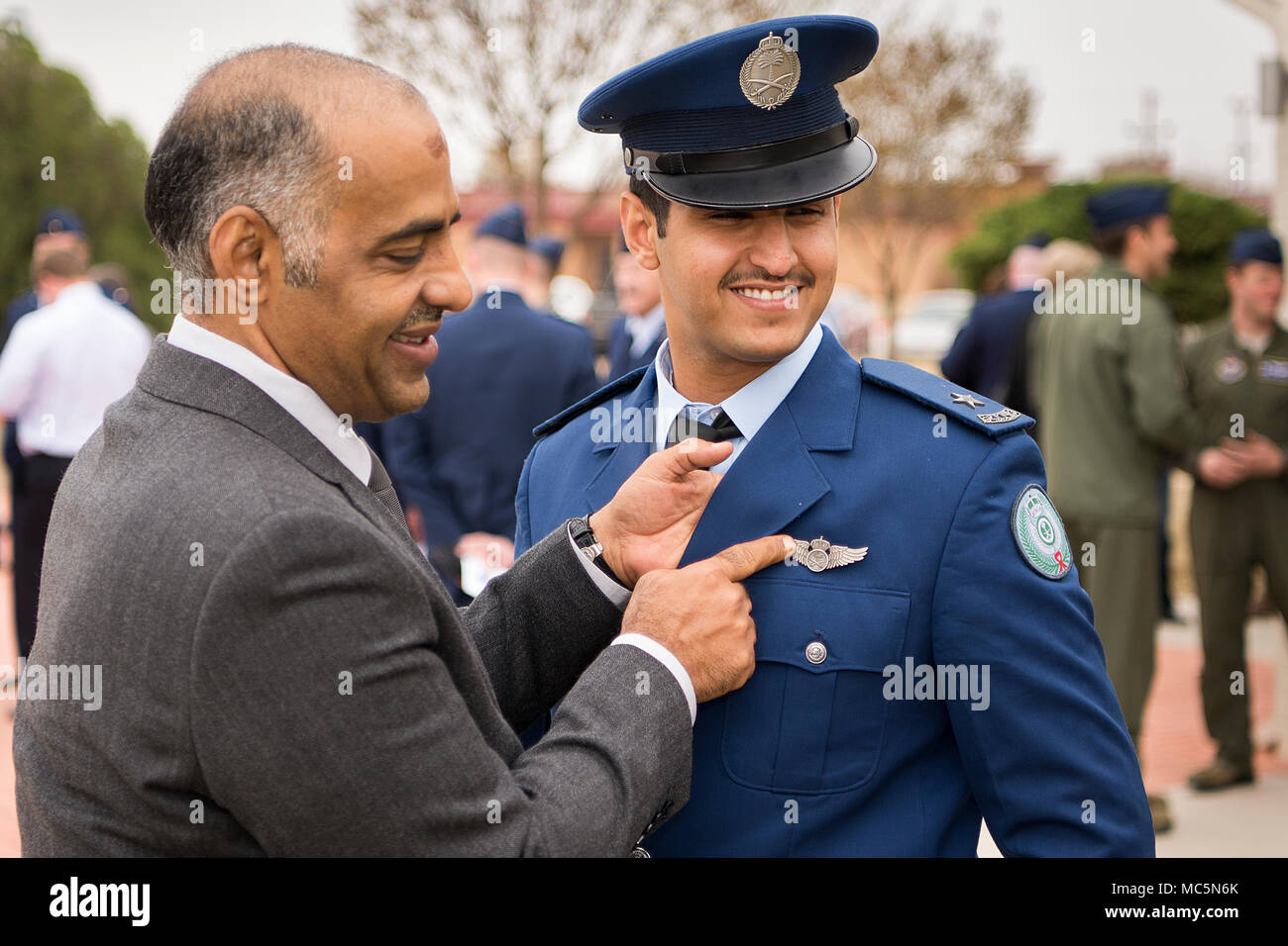 2nd Lt. Bader Alzakari, a pilot assigned to the 71st Student Squadron, has his wings pinned on by his father after the graduation ceremony April 6, 2018, at Vance Air Force Base, Oklahoma. Through a partnership with our allied country, pilots from around the world come to Vance to train. (U.S. Air Force photo by Airman 1st Class Taylor Crul) Stock Photo