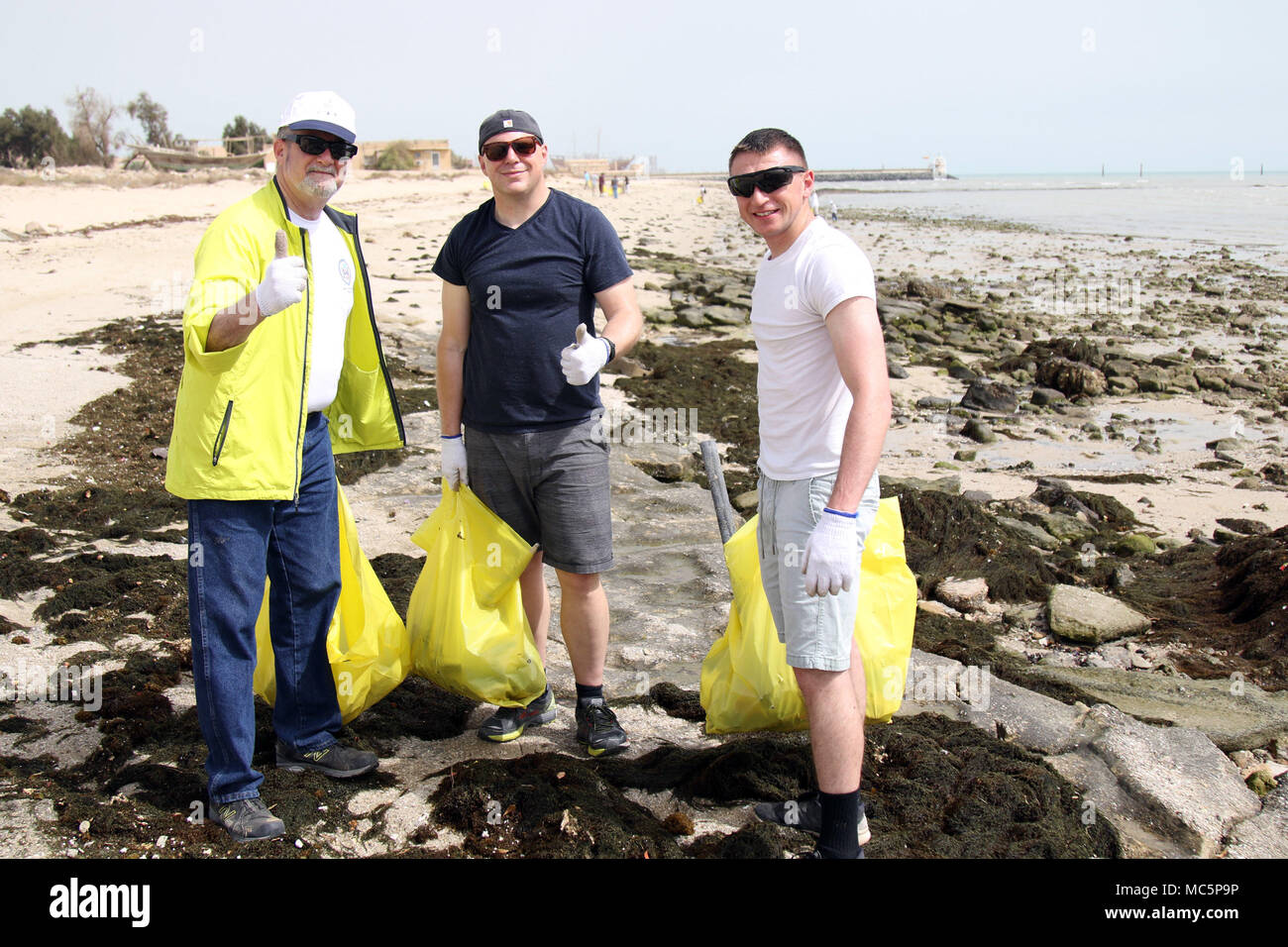 KUWAIT CITY, Kuwait — U.S. Ambassador to Kuwait Lawrence Silverman (left) pauses during a cleanup at Anjafa Beach for a photo with Pa. Army National Guard Soldiers Sgt. Timothy Reed (center) of Latrobe and Spc. Anthony Massaro of Philadelphia on April 7, 2018. Reed and Massaro are with Charlie Company, Headquarters and Headquarters Battalion, 28th Infantry Division and are deployed to Kuwait as part of Task Force Spartan. The event was the latest in an ongoing effort to rid Kuwait beaches of pollution. (U.S. Army photo by Sgt. 1st Class Doug Roles) Stock Photo