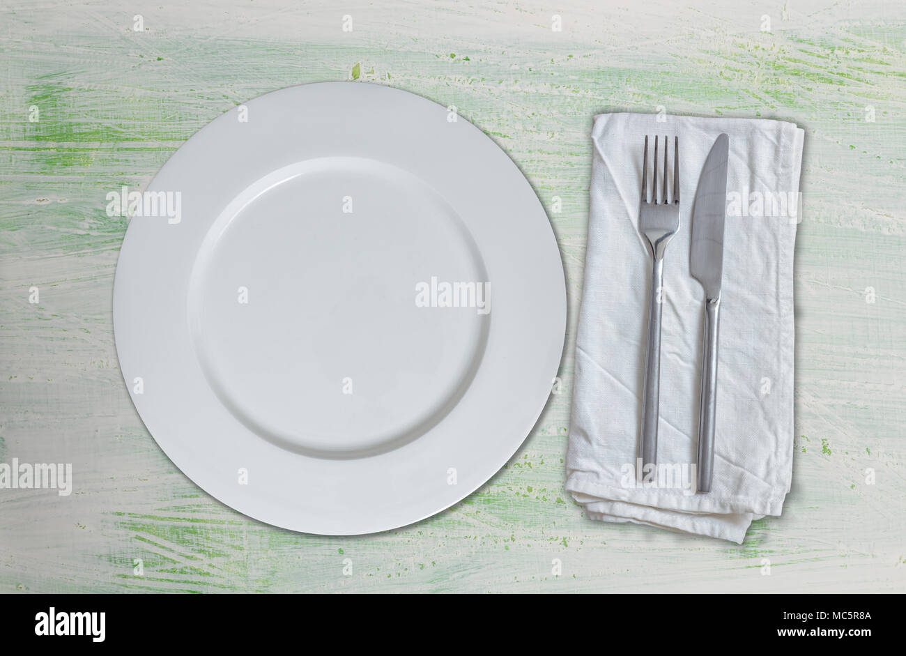 Empty dish and cutlery on green white wood. Stock Photo