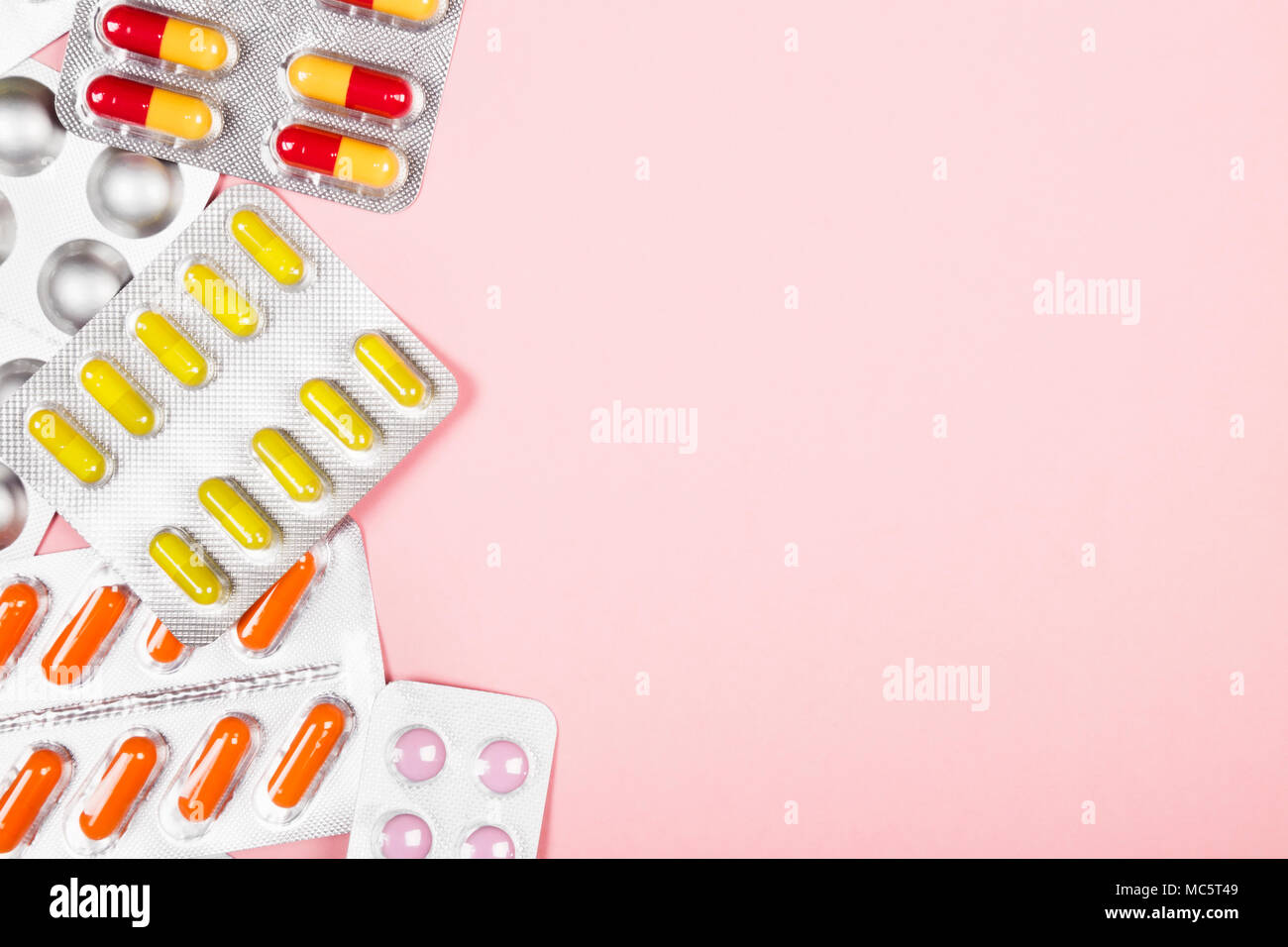Various medicine pills on pink background. Top view, copy space Stock Photo