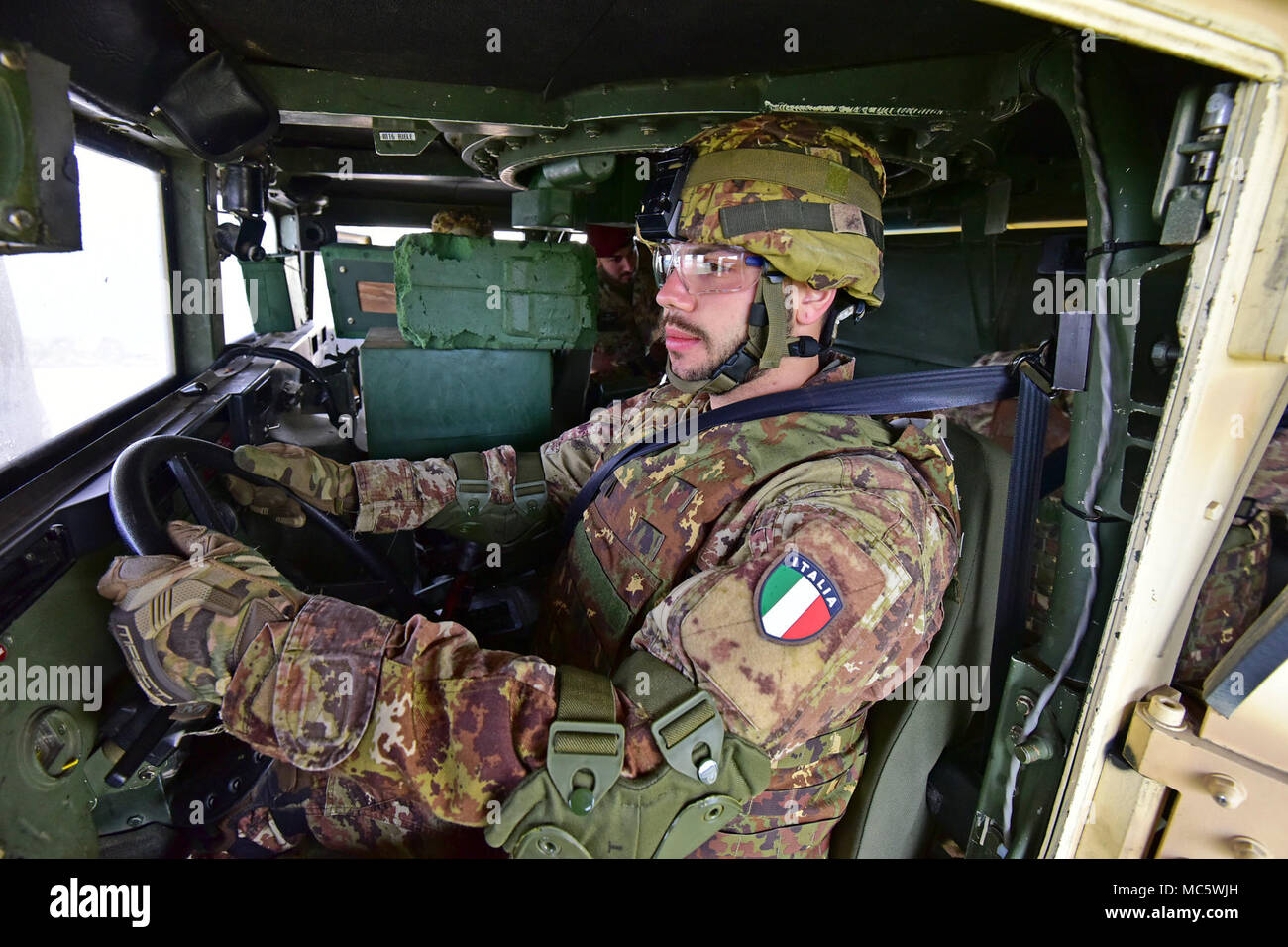 An Italian Army Paratrooper assigned to Regiment “Savoia Cavalleria” Folgore Brigade Grosseto, conduct training using High Mobility Multipurpose Wheeled Vehicle (HMMWV) egress assistance trainer (HEAT), at Caserma Ederle Vicenza, Italy, March 29, 2018. The simulator allows soldiers to practice exit from vehicles, skills and engage in realistic scenarios. Italian Paratroopers use U.S. Army RTSD South equipment to enhance bilateral relations and to expand levels of cooperation and the capacity of the personnel involved in joint operations. Stock Photo